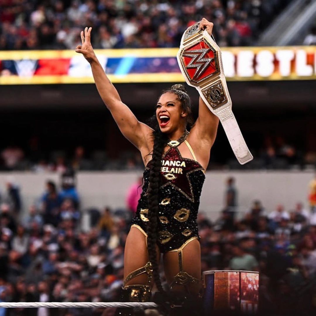 Bianca Belair with her championship belt celebrating inside the ring